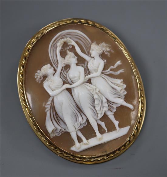 A yellow metal mounted oval cameo brooch carved with the Three Graces, 56mm.